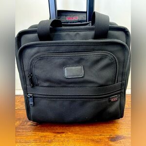 TUMI Black computer bag with wheels and 4 pockets.